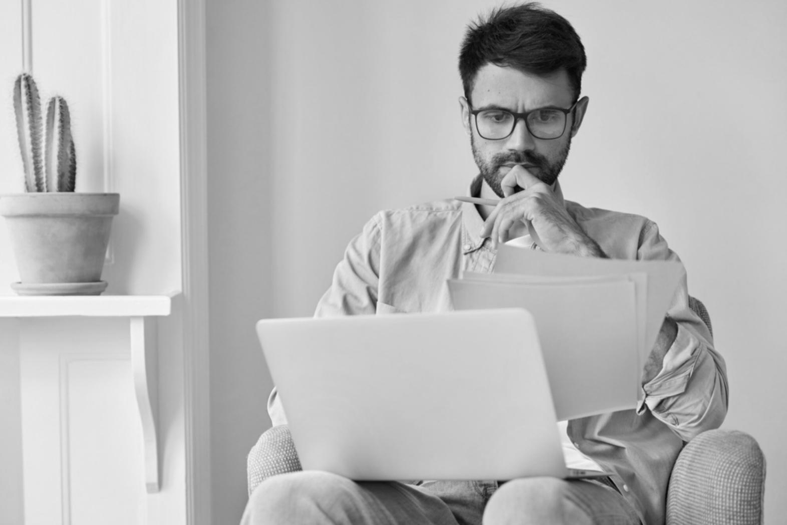 Person reviewing financial documents with calculator and charts
